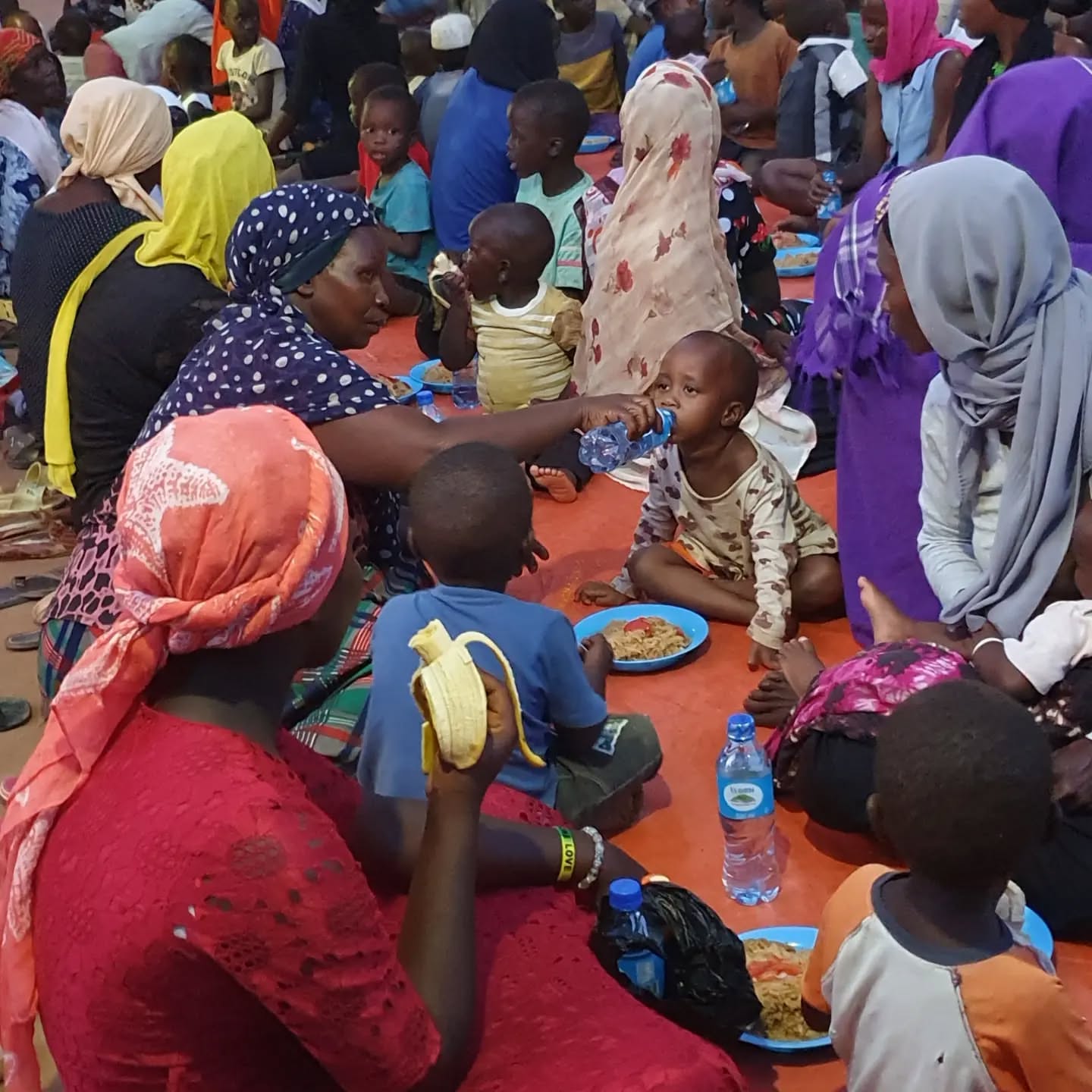 Families sharing a meal at a community feeding activity